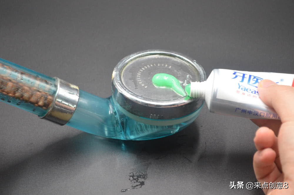 把牙膏涂抹在淋浴喷头上,把牙膏挤到喷水壶里