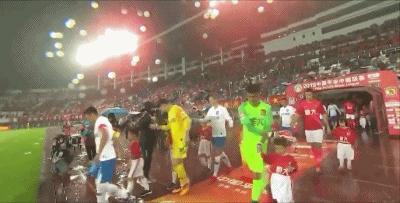 国安球员为球童遮雨,浙江队队员为球童遮雨