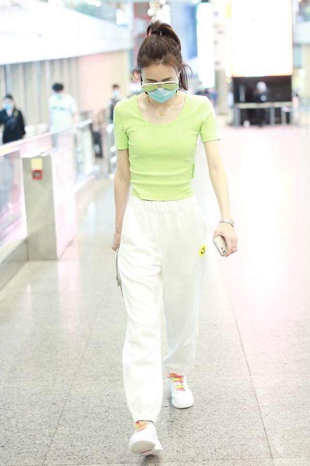 王丽坤身穿荧光色的短袖，搭白色运动裤，可亮眼可好看了