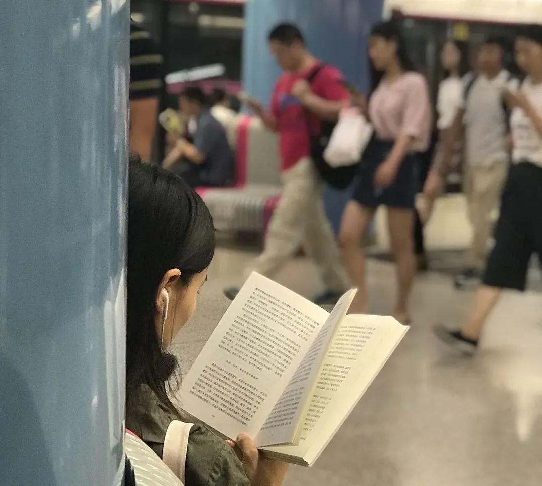 北京通勤路上，她用镜头记录2000个捧着书的人